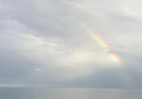 photo of a rainbow in a cloudy gray sky