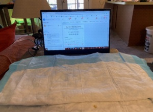photo of table covered in pads and laptop screen