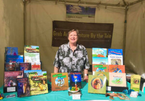 Elaine smiling from her booth at the 2019 TFOB