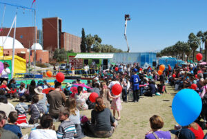 A crowd of families with young children sit around a book mobile at the 2010 Tucson Festival of Books