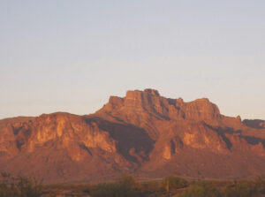 A shadow that resembles a cougar lies between two mountain peaks.