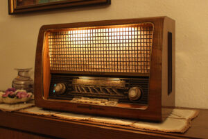 An antique analog radio sitting on a chest.