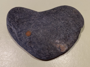 A gray stone naturally shaped into a heart.