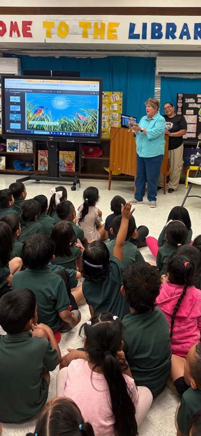 A series of three images depicting Elaine as she presents to a group of school children in guam. 