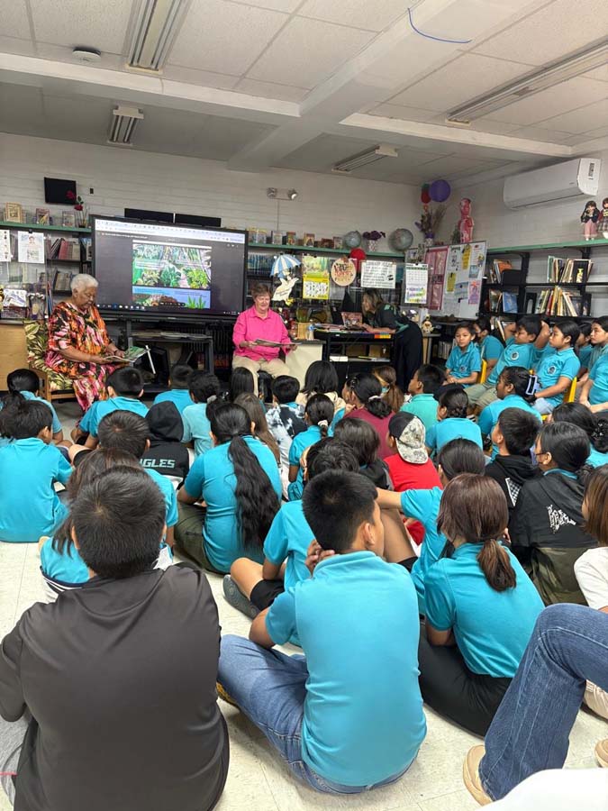 A series of three images depicting Elaine as she presents to a group of school children in guam. 