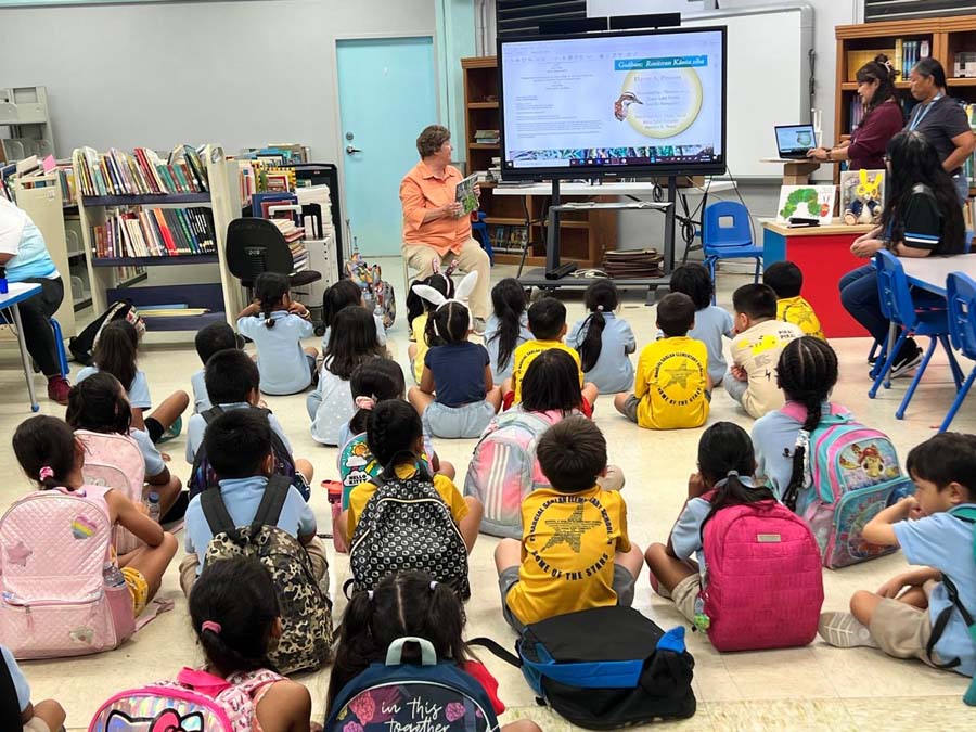 A series of three images depicting Elaine as she presents to a group of school children in guam. 