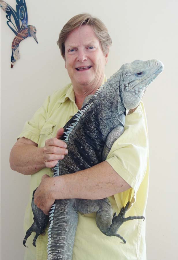 Elaine holding a large blue-gray iguana with dark stipes on his torso.
